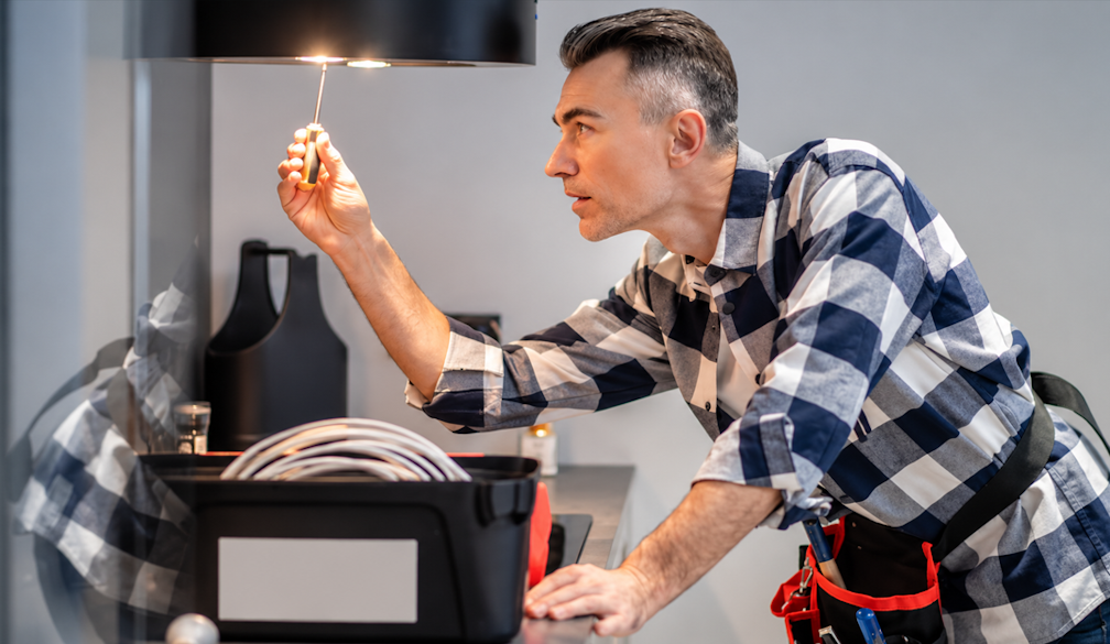 Focused Handyman Adjusting Pendant Light
