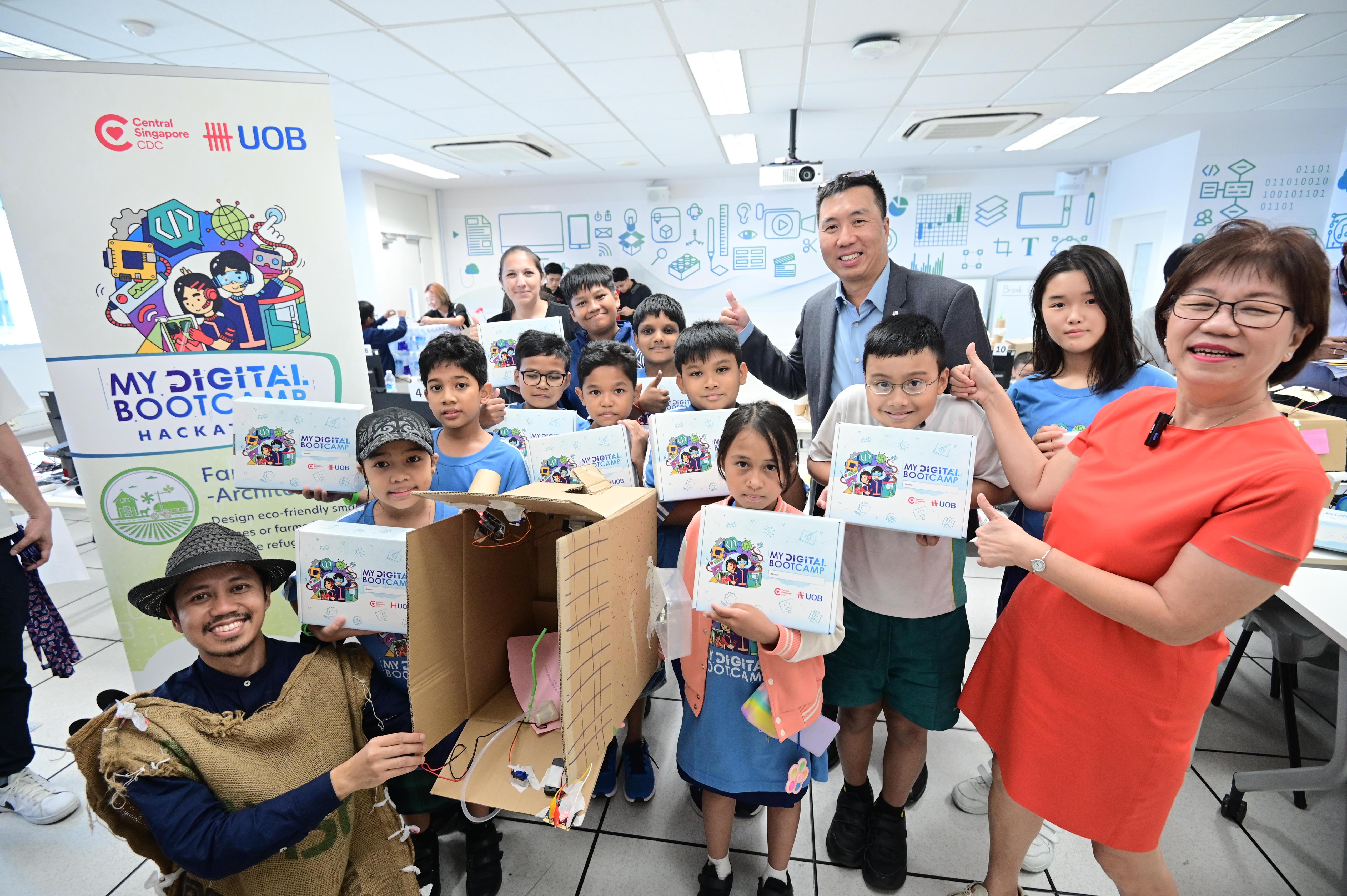 Mayor Denise Phua (extreme Right) and UOB’s Mr Leonard Tan (centre, in jacket) interact with kids at “My Digital Bootcamp”
