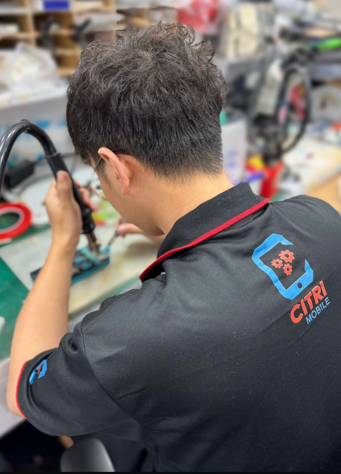 A Citri Mobile technician performing internal diagnostics at a fully equipped repair station in Singapore.